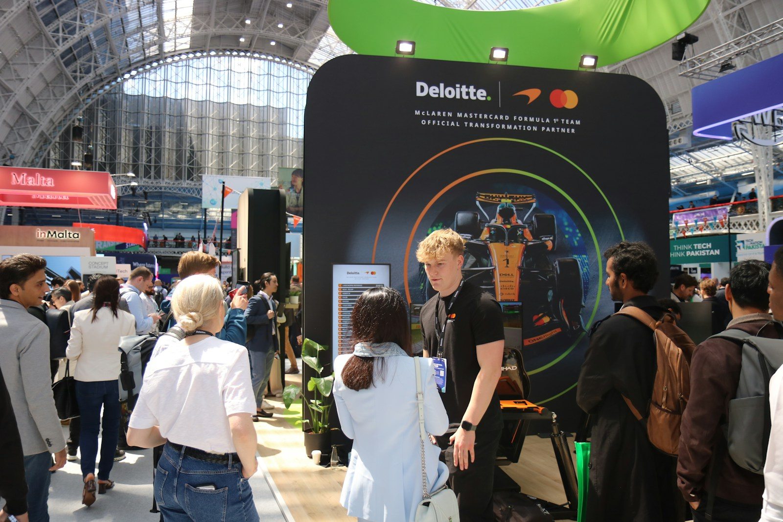 Visitors in the open space in front of an exhibition stand