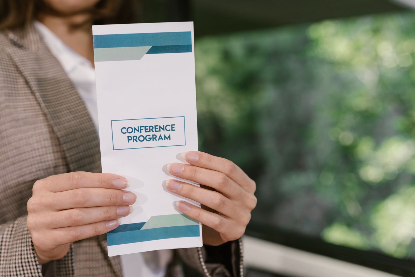 Person holding a printed conference program