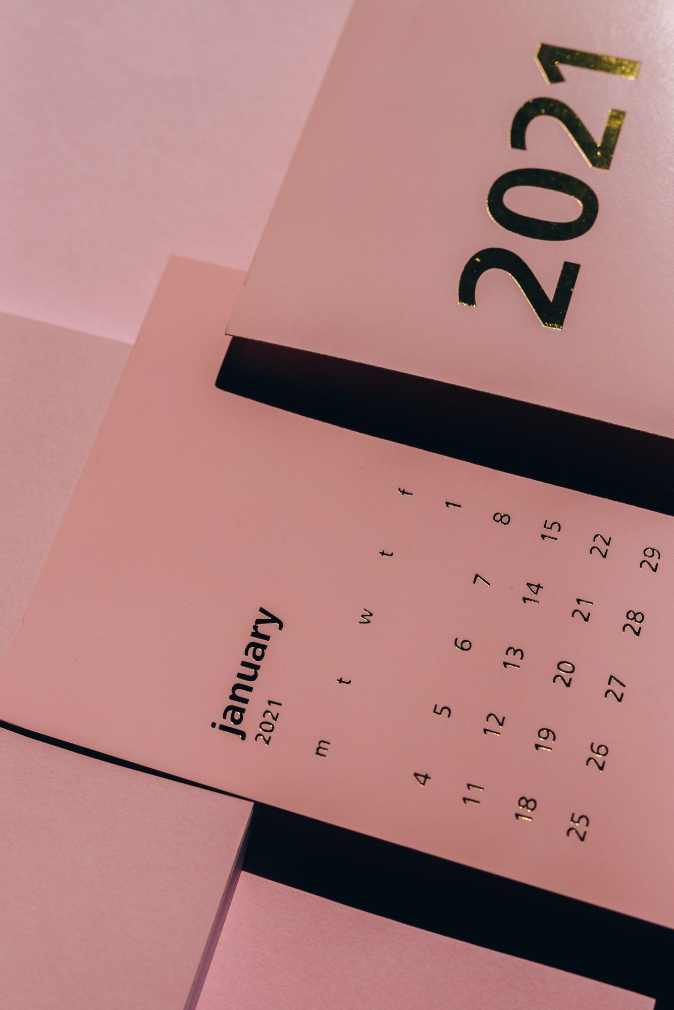 Printed paper calendar on a pink background