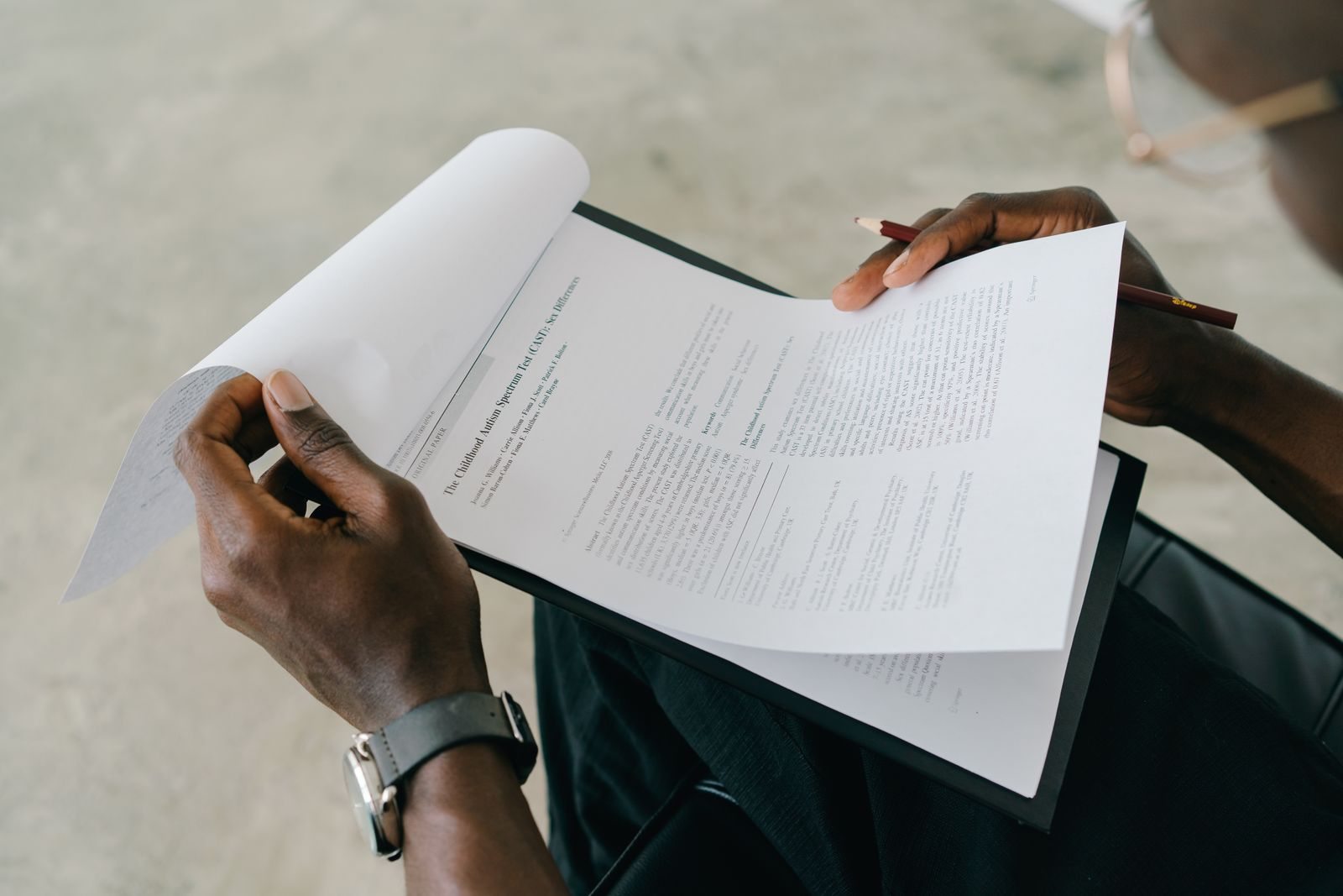 Hands holding and reviewing printed documents