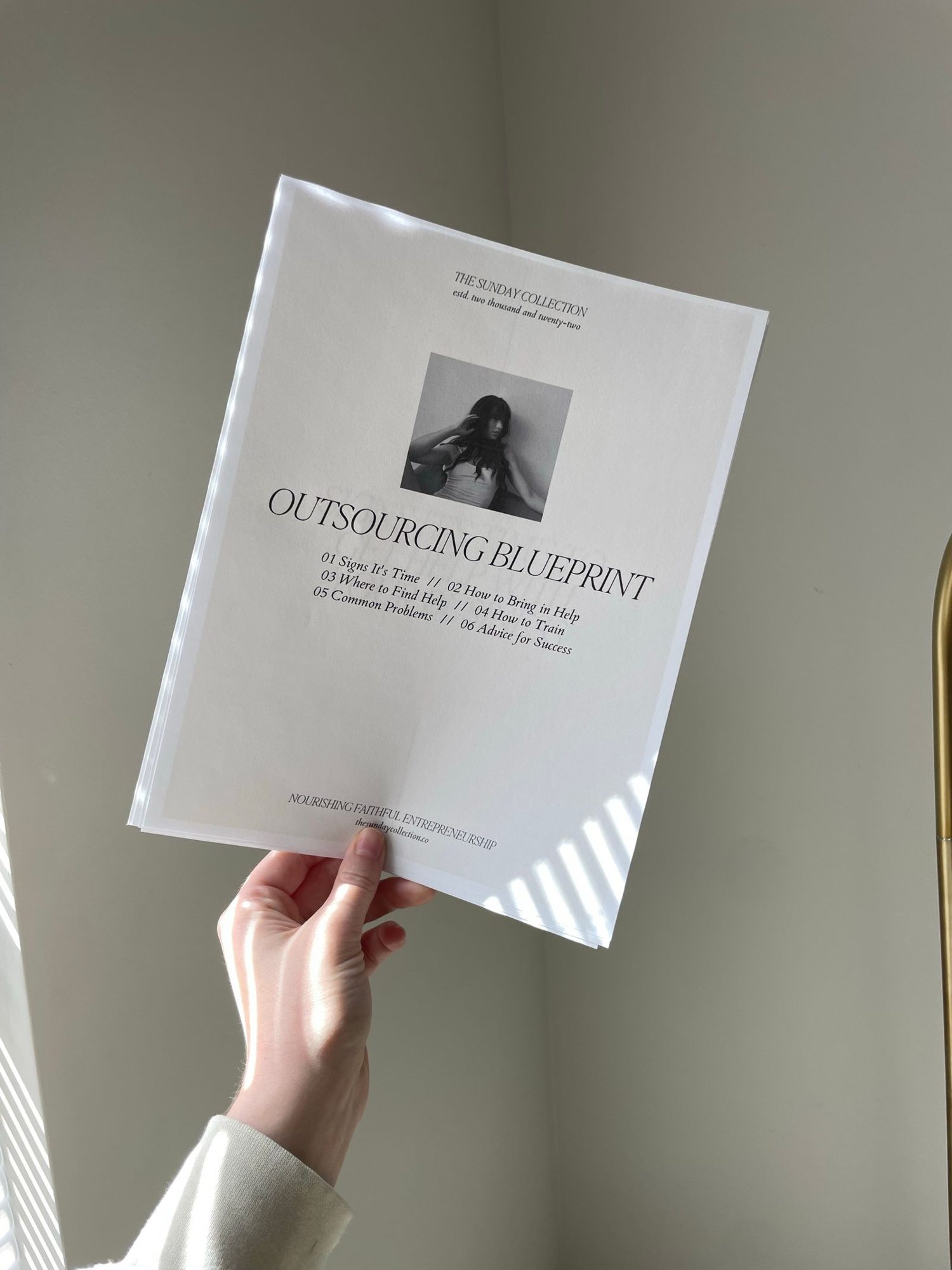 A hand holding a printed document