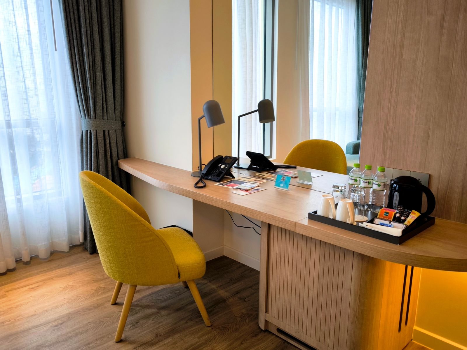 Hotel desk and chair beside a window with natural light