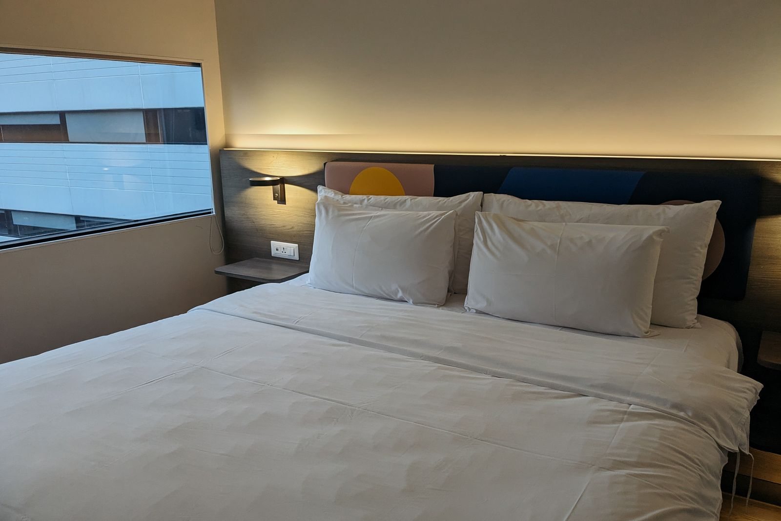 Hotel bed beside a window