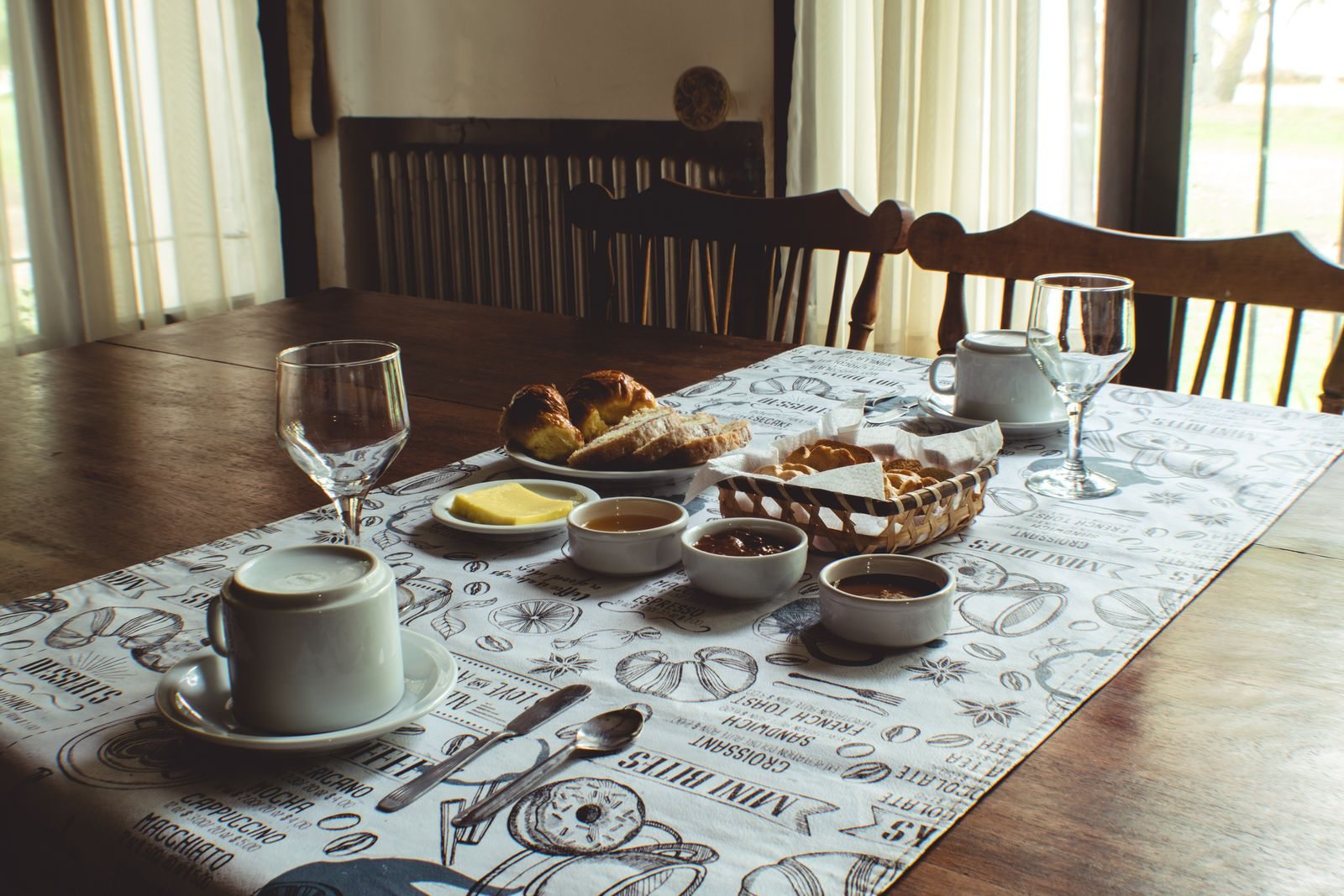 Breakfast table with bread, drinks and tableware