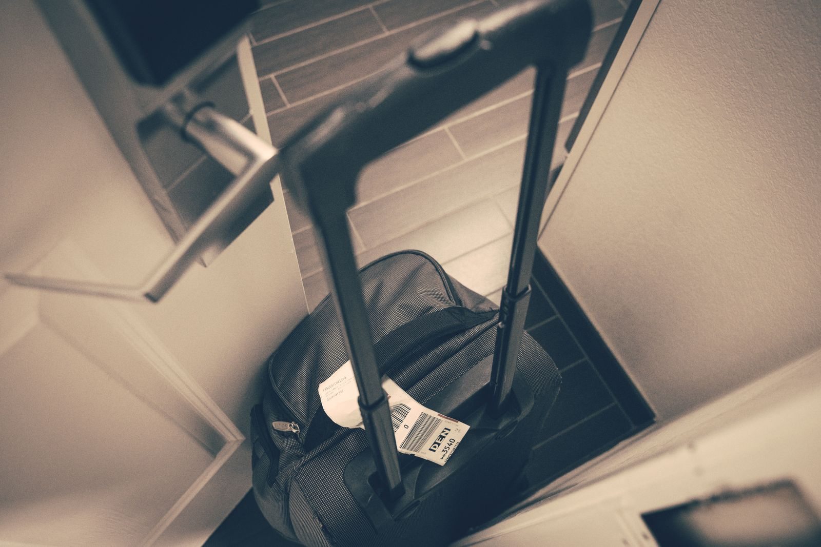Rolling suitcase beside a room door