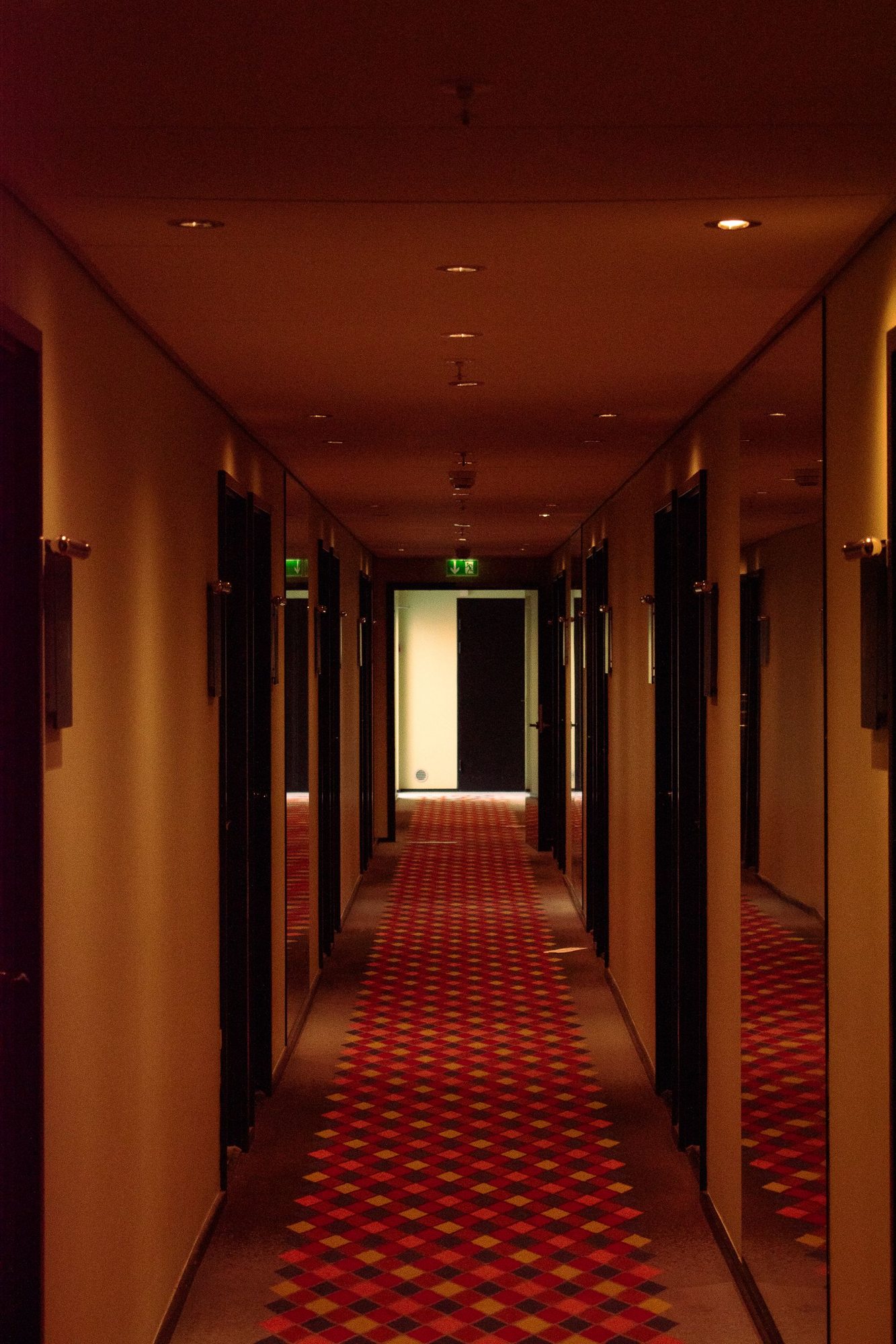 Lit hotel corridor with room doors