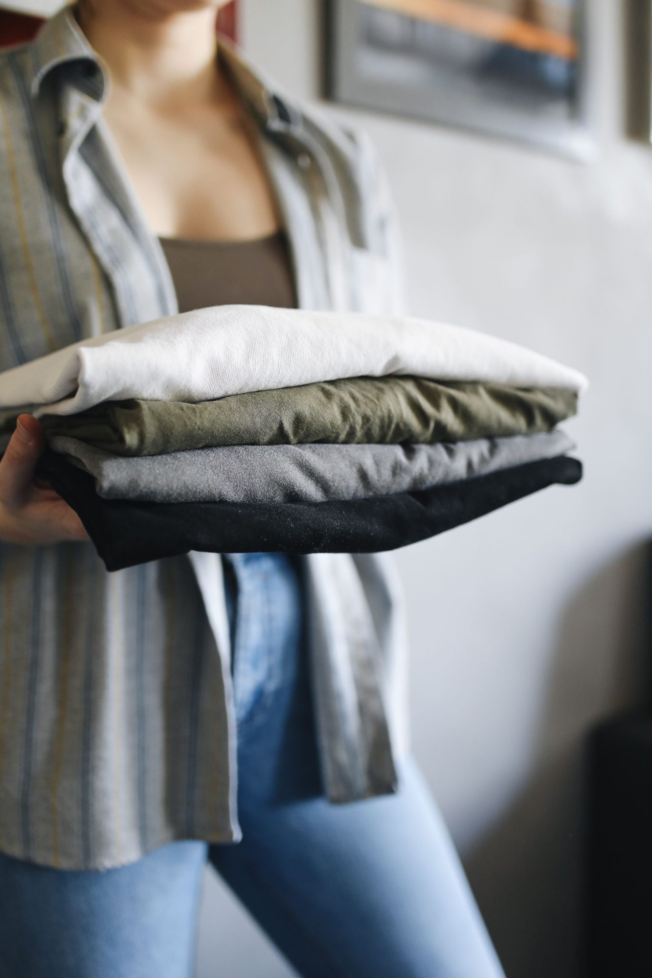 Person holding neatly folded shirts