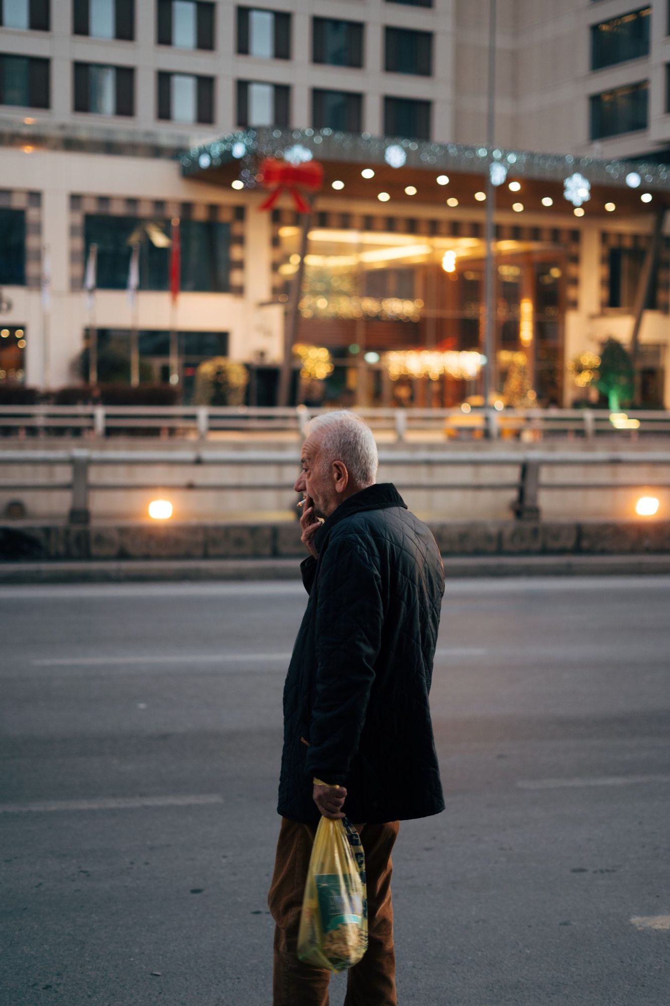 Pedestrian on a lit city street in the evening